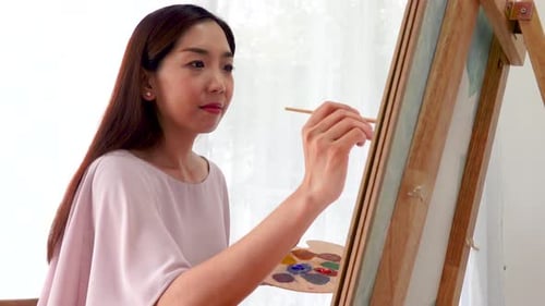 Woman Painting on Canvas with Brush