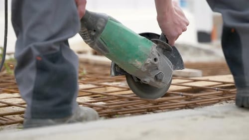Construction Worker Cutting Fabricated Steel Bar For Slab Using Abrasive Cutting Disc. close up