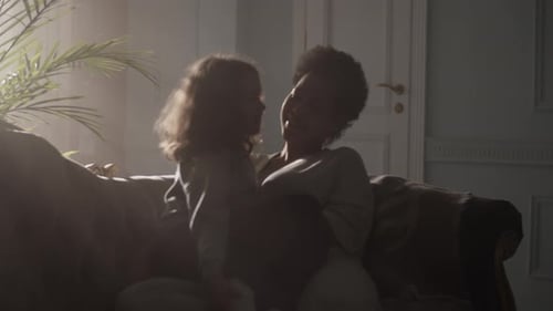 Mother and Child Smiling on Couch Indoors