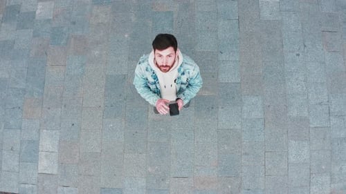 Aerial View of Man Using Smartphone in City