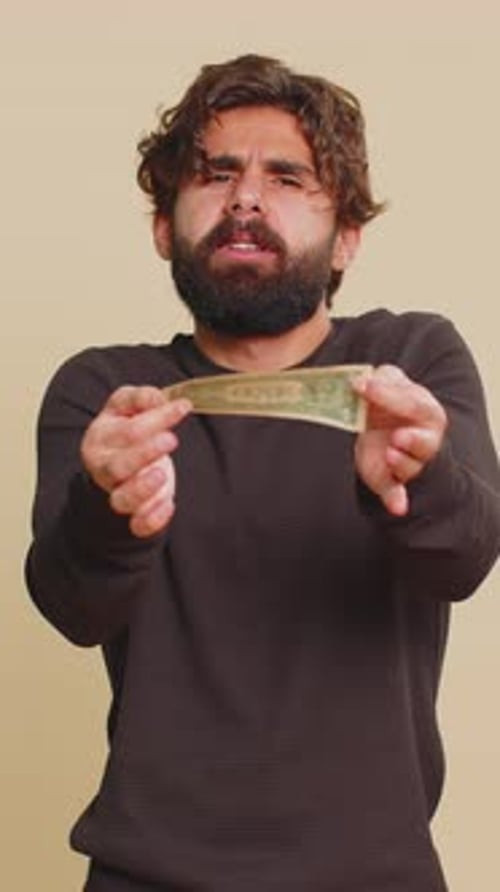 Man Holding and Counting Money Looking Sad