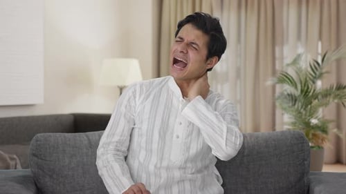 Sick Indian man having neck pain