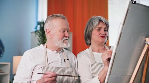 Senior Couple Painting Together at Home on Canvas