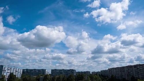 White Clouds Drifting Above Urban Cityscape