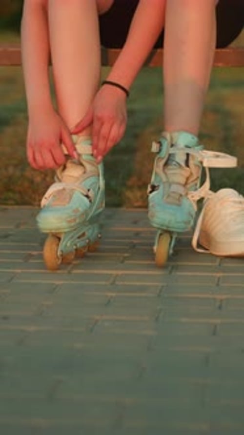 Young Adult Prepares Roller Skates on Urban Pavement