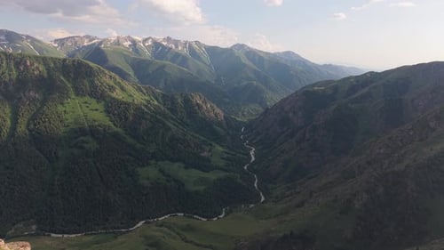 Breathtaking Valley and River Winding Through Lush Green Mountains
