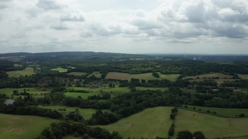 Aerial view of the English village surrounded by fields and forests. Shot on a sunny day.