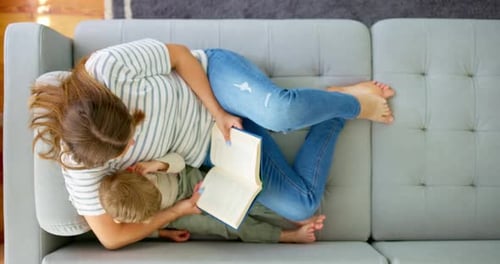 Woman and Child Reading Together on Couch