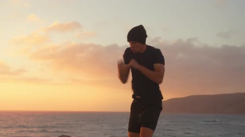 Athlete Boxing Into Air Near Sea Under Sky During Sunset