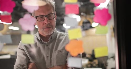 Mature businessman brainstorming ideas at night in an office