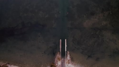 Aerial view of a concrete jetty extending into the calm waters
