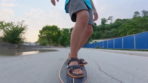 POVstyle Low Angle Shot of Child Riding Skateboard on Street Close Up of Feet in Motion Summer