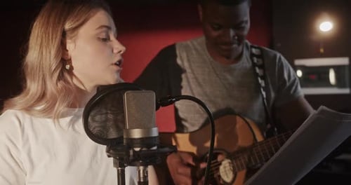 Guitarist and Singer Recording Song in Studio