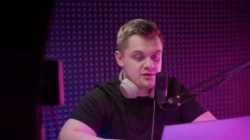 Man Talks into Microphone in Purple Lit Studio