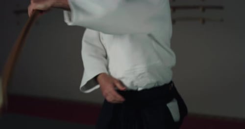 Filmaufnahme eines Kämpfermeisters, der mit einem Holzschwert beim Aikido-Training auf modernem Japanisch trainiert m