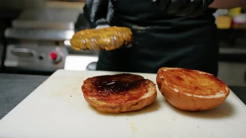 Chef Preparing Delicious Cheeseburger in Kitchen
