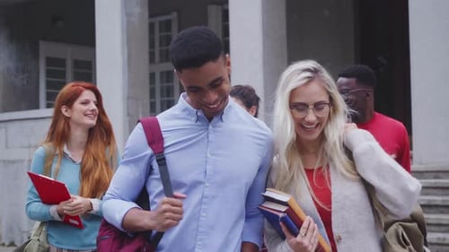 Happy smiling multiethnic university students walking outside on campus in conversation