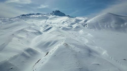 Luftaufnahme der kurvenreichen Autobahn durch schneebedeckte Berge