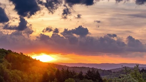 Multicolored Sunset in a Cloudy Sky Over a Mountain Valley with a Autumn Forest