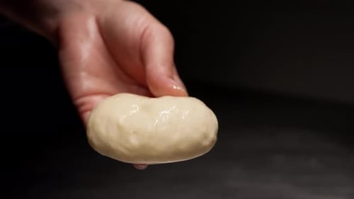 Close-Up of Woman Preparing Dough on Metal Surface