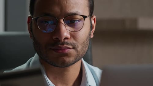 Adult Man with Glasses Holding a Credit Card near a Laptop
