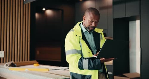 Laptop, renovation and serious with black man in kitchen for home improvement or upgrade project