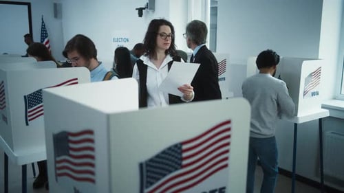 Woman in Glasses Comes to Vote in Booth in Polling Station