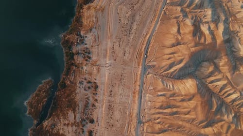 Top View Drone Shot: Two Cars on Desert Road Between Judean Hills and Dead Sea at Sunrise