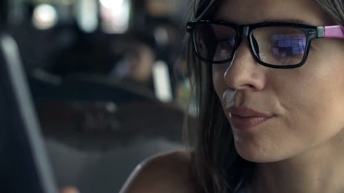 Young Woman with Glasses Using Tablet Computer Sitting in Cafe 30s