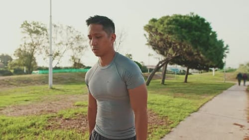 Young man walking along the path in the park