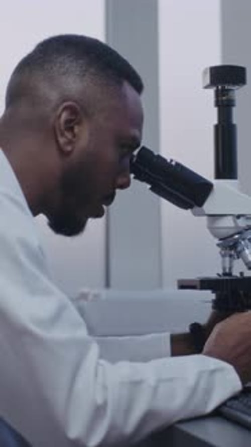 Researcher Looks Through Microscope in the Lab