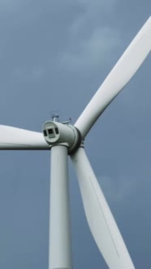 Windmill or wind turbine on wind farm in rotation