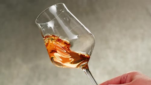 Orange or White Wine Bottle and Glass Against a Sunset in a Peaceful Vineyard Pouring of Ecological