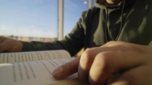 Man Reading a Book by a Bright Window