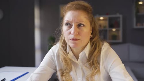 An elderly businesswoman working in a home office is brainstorming a new idea.