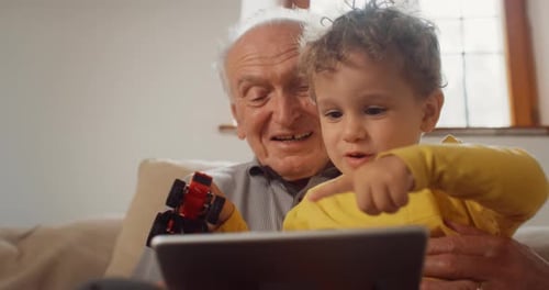 Grandfather and Grandson Using a Tablet at Home