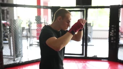 Man Shadow Boxing in Gym inside Cage