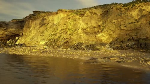 Dramatic Scene with Glowing Cliffs and Shimmering Reflections Across Bay