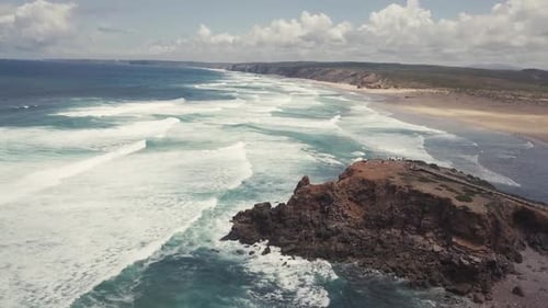 Aerial Drone View Of Turquoise Ocean Waves Crashing Against Rocks