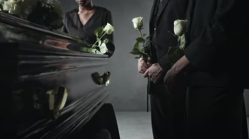 People in Black, Holding White Roses, Standing Mournfully Near Coffin at Funeral