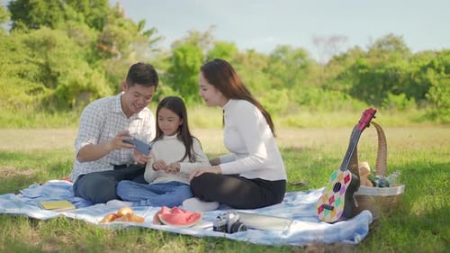 Family Takes a Picnic on a Grassy Field