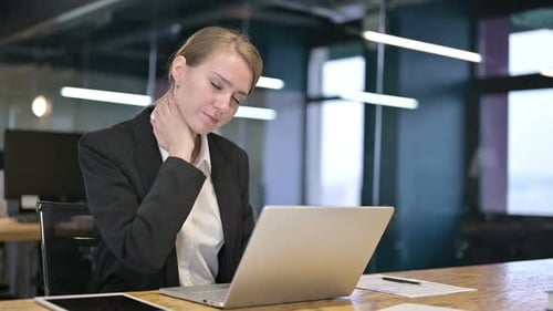 Hardworking Young Businesswoman having Neck Pain in Office