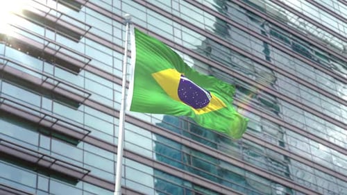 Brazilian Flag Waving on Flagpole in Front of Modern Building