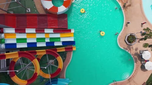 Tourists Enjoying Summer at Water Park with Colorful Slides and Pools