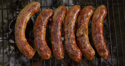 Delicious juicy sausages, cooked on the grill with a fire.