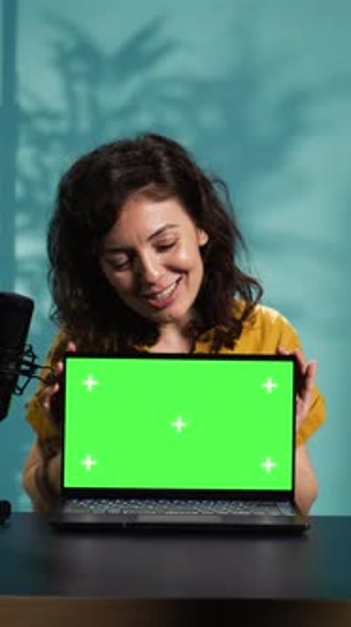 Woman Presenting Laptop with Green Screen Display