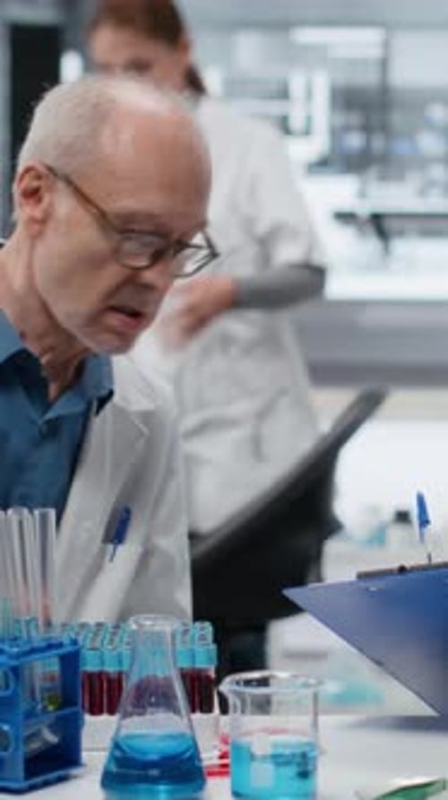 Vertical Video Medical Team in Lab Conducting Research on Blood Sample Taking Notes
