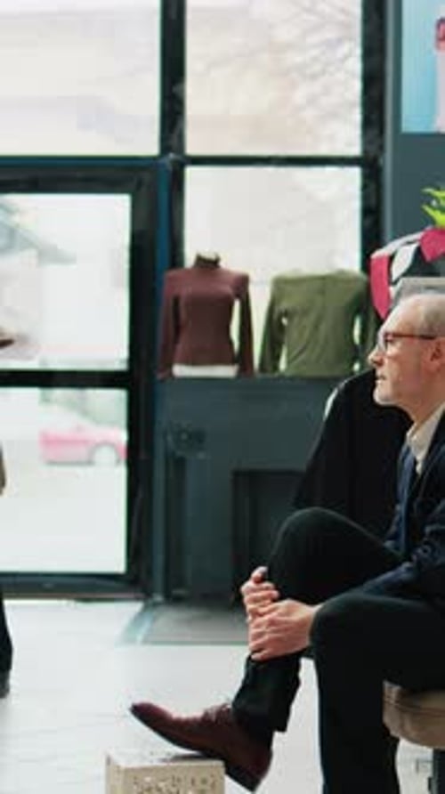 Man Tying Shoelaces in Clothing Store