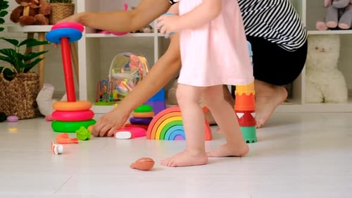 Child and Adult Playing with Colorful Toys