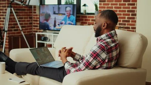Man Relaxing on Sofa During Video Conference Call